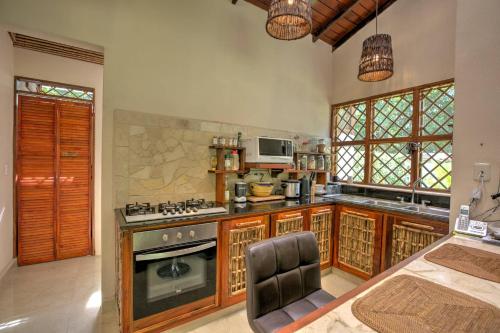コクレスにあるVilla # 1 - Zen Luxury VillaSq M Gardenの木製キャビネットとコンロ付きの広いキッチン 上部オーブン