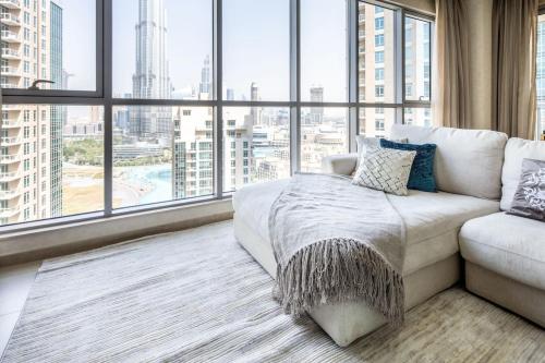 a living room with a couch and a large window at Frank Porter - The Residences in Dubai