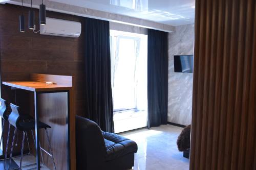 a living room with a chair and a table and a window at River Park apartments in Dnipro