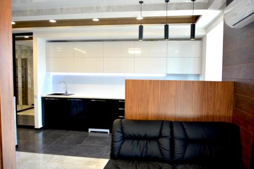 a kitchen with a black leather couch in a room at River Park apartments in Dnipro