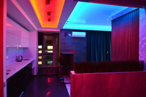 a kitchen with pink and purple lighting and a bar at River Park apartments in Dnipro