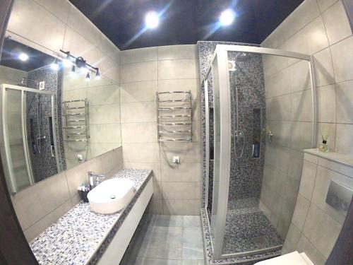 a bathroom with a sink and a shower at River Park apartments in Dnipro