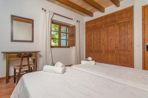 a bedroom with a bed and a desk and a window at Mercader in Alcudia