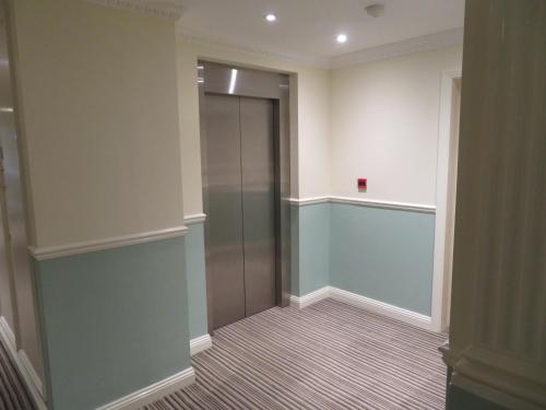 a hallway with a glass elevator in a building at Burlington Mansions in Bournemouth
