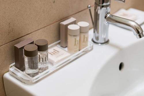 a bathroom sink with a shelf with cosmetics on it at Helios Hotel & Restaurant in Monza