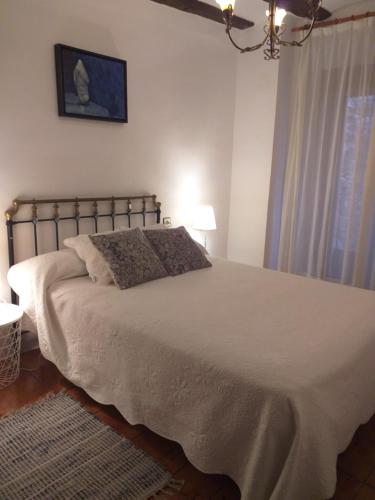a bedroom with a large white bed and a window at Apartamento Tras Catedral in Teruel
