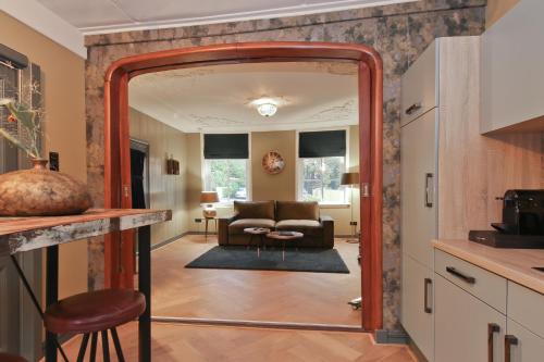 a kitchen with an archway into a living room at Small Luxury Boutique Hotel Wilma J in Vinkeveen