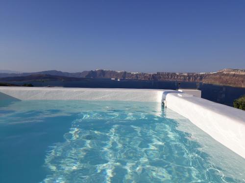 a swimming pool with a view of the water at Admiral's House Santorini in Akrotiri