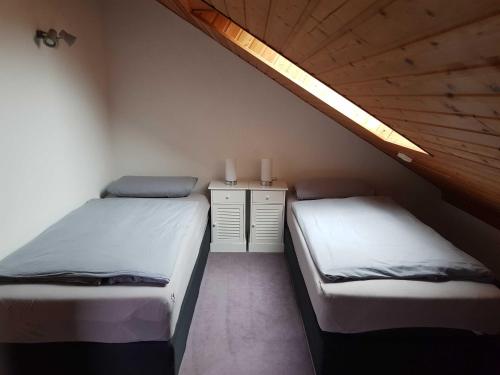 a bedroom with two beds and a wooden ceiling at Ferienwohnung Schwarz in Gasseldorf