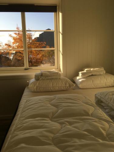 two beds sitting in a room with a window at Lofoten Sea Lodge in Sennesvik