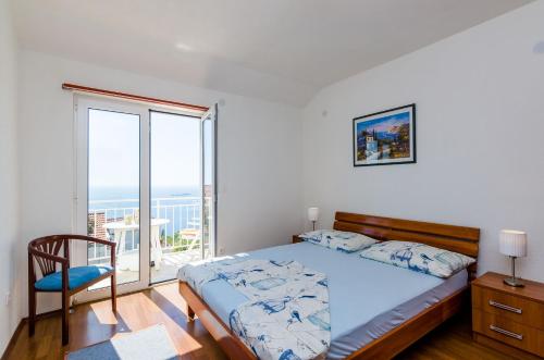 a bedroom with a bed and a large window at Apartments Joy in Cavtat
