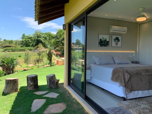 a bedroom with a bed and sliding glass doors at Paraíso do Morro dos Ventos in Chapada dos Guimarães