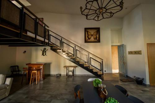 a living room with a staircase and a chandelier at Villa Toscana ValQuirico Lofts & Suites Hotel Boutique in Santeagueda