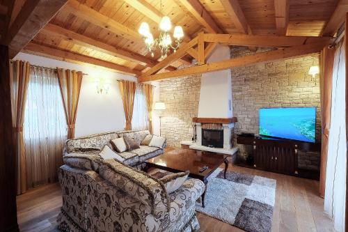a living room with a couch and a tv at Luxury VILLA LE ROSE in Poreč