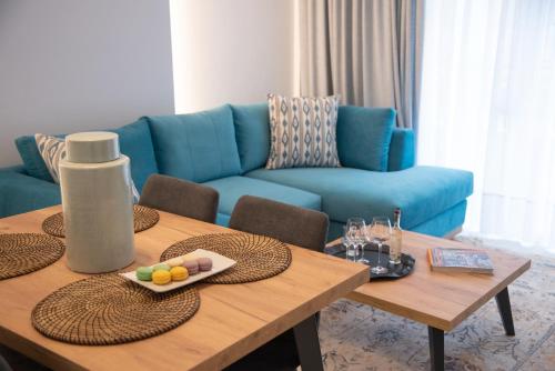 a living room with a table and a blue couch at Onar Modern Luxury Apartments in Kavála