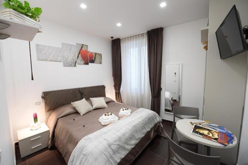 a bedroom with a bed and a desk and a television at B&B IN CENTRO STORICO SALERNO in Salerno