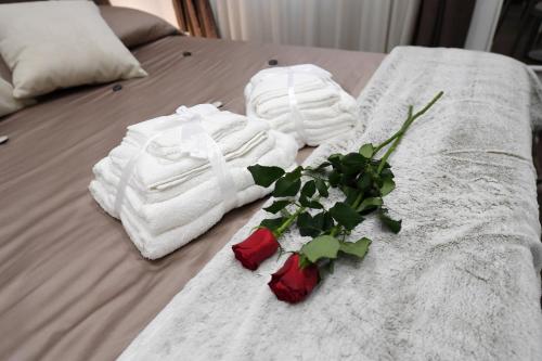 a bed with white towels and a bouquet of roses at B&B IN CENTRO STORICO SALERNO in Salerno
