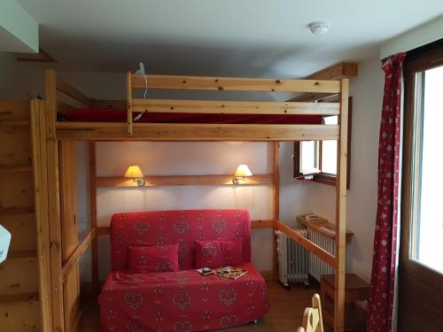 - une chambre avec des lits superposés et une chaise rouge dans l'établissement Coeur des Alpes, à Combloux