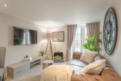 a living room with a couch and a tv at Heritage Mews Nottingham in Nottingham