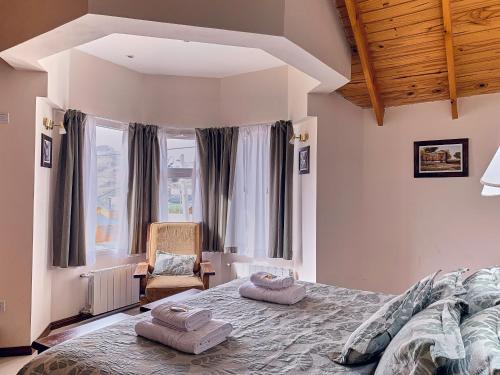 a bedroom with a large bed with two pillows on it at Hotel Cumbres Nevadas in El Chalten