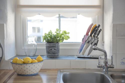 a kitchen sink with a bowl of lemons next to a window at Little Trevara, Marazion in Marazion