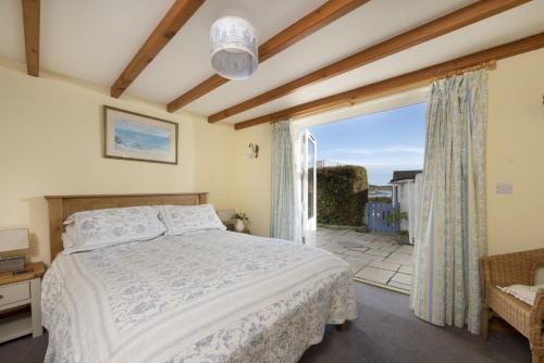 a bedroom with a bed and a large window at Little Trevara, Marazion in Marazion
