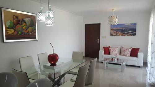 a dining room with a glass table and chairs at Paraiso de verano in Santiago de los Caballeros
