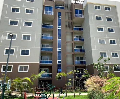 an apartment building with a playground in front of it at Paraiso de verano in Santiago de los Caballeros