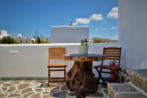 d'une table et de chaises sur une terrasse dotée d'un stuc d'arbres. dans l'établissement Dioni lux inn, à Pachaina