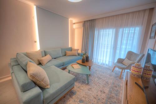 a living room with a blue couch and a tv at Onar Modern Luxury Apartments in Kavála
