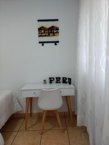 un escritorio blanco con una silla y una foto en la pared en HABITACIÓN ALBORADA 1 con baño privado, en Lima