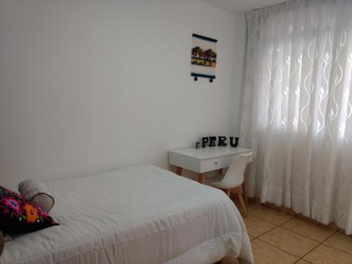 1 dormitorio con cama, escritorio y ventana en HABITACIÓN ALBORADA 1 con baño privado, en Lima