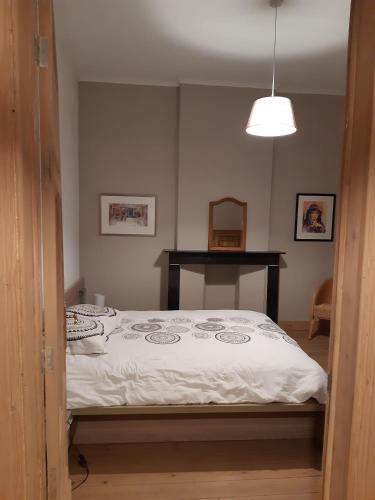 a bedroom with a bed with a white comforter at La Maison du Maître in Dinant