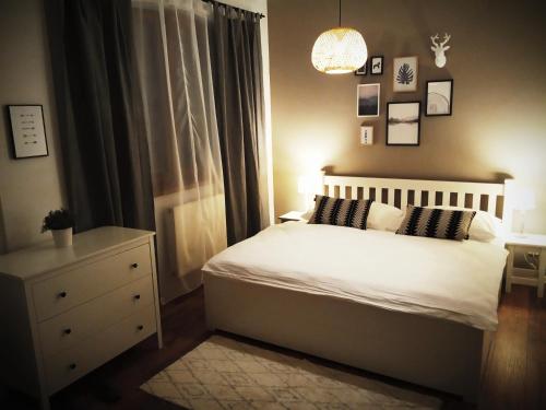 een slaapkamer met een wit bed en een dressoir bij APARTMAN LINDA - VEĽKÁ LOMNICA in Veľká Lomnica