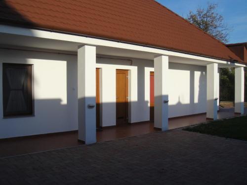 un edificio con paredes blancas y techo rojo en Paks Panzió en Paks
