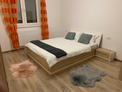 Schlafzimmer mit einem Bett, einem Fenster und einem Teppich in der Unterkunft AMA Residence in Timişoara