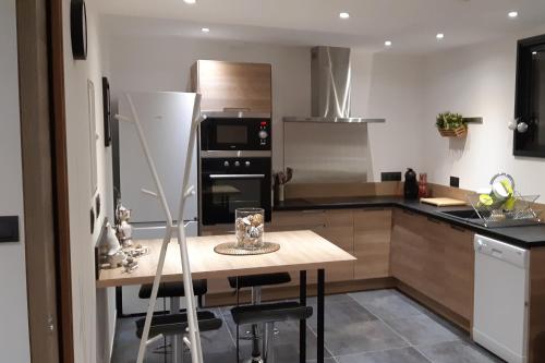 a kitchen with a wooden table and a stove top oven at Gite Le Petit Malsbach Eguisheim 3 étoiles in Eguisheim