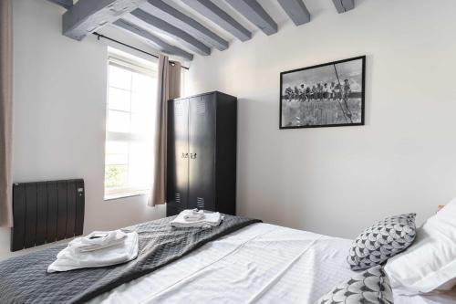 a bedroom with a bed and a large window at La Dimiere - Le Postel - Appartements de standing en hyper-centre - Louviers in Louviers