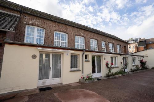 a large brick building with white doors and windows at La Dimiere - Le Postel - Appartements de standing en hyper-centre - Louviers in Louviers