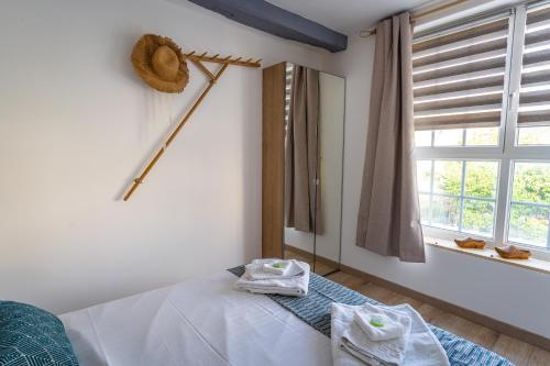 a bedroom with a bed with two towels on it at La Dimiere - Le Postel - Appartements de standing en hyper-centre - Louviers in Louviers