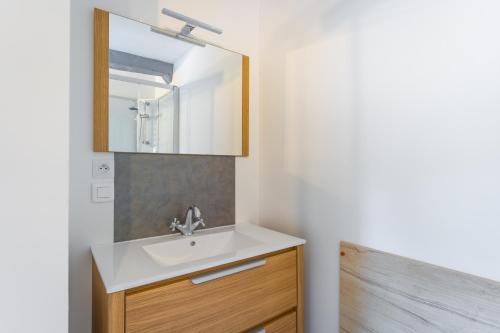 a bathroom with a sink and a mirror at La Dimiere - Le Postel - Appartements de standing en hyper-centre - Louviers in Louviers