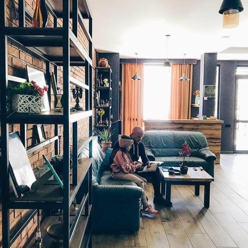 a person sitting on a couch in a living room at Hilltop Kazbegi in Stepantsminda
