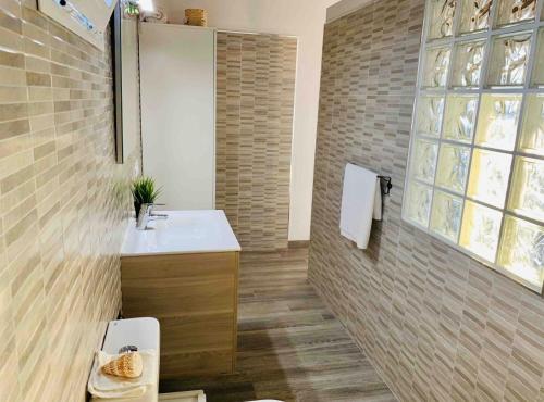 a bathroom with a sink and a toilet and a window at Loft La ISLA in Playa Blanca