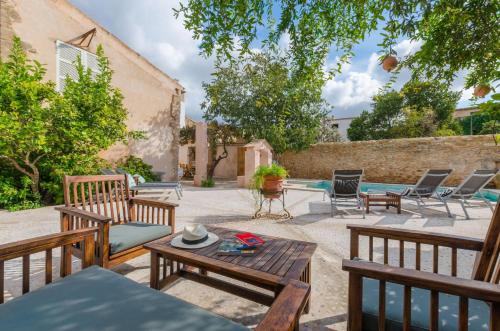 a patio with benches and a table and a pool at Jaume II in Llucmajor