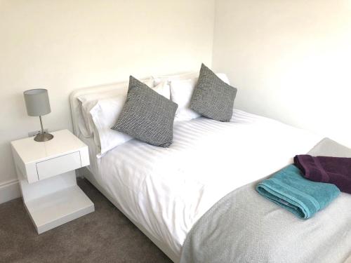 1 cama blanca con 2 almohadas y una mesita de noche en Ashbrook Harwell 18, en Didcot