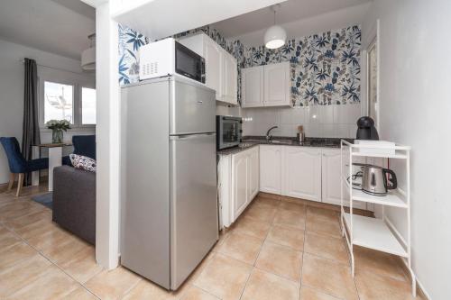  La cuisine est équipée de placards blancs et d'un réfrigérateur. dans l'établissement Luxury Suite Sea Front, à Playa Honda