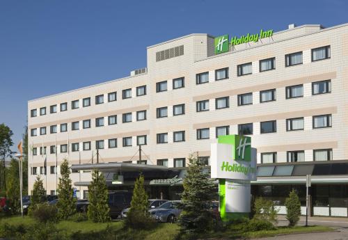 - un grand bâtiment blanc avec un panneau hilton devant dans l'établissement Holiday Inn Helsinki-Vantaa Airport by IHG, à Vantaa