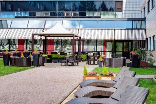 um pátio com cadeiras e um gazebo num edifício em Holiday Inn Helsinki-Vantaa Airport, an IHG Hotel em Vantaa