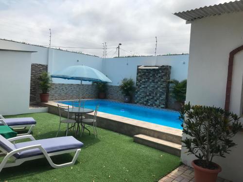 a patio with a table and chairs and a pool at Casa Blue Tortuga in Ballenita