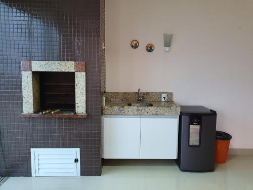 a small kitchen with a sink and a counter at Cobertura Jacuzzi Vista Mar in Bombinhas
